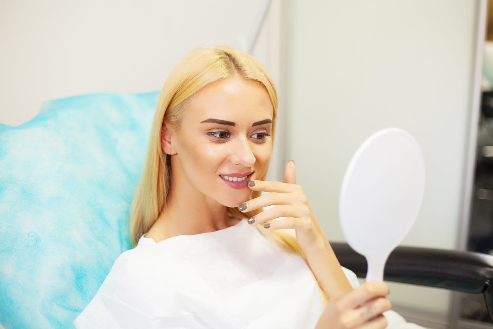A patient admiring her smile after dental implant treatment at Marchwood Dental Practice